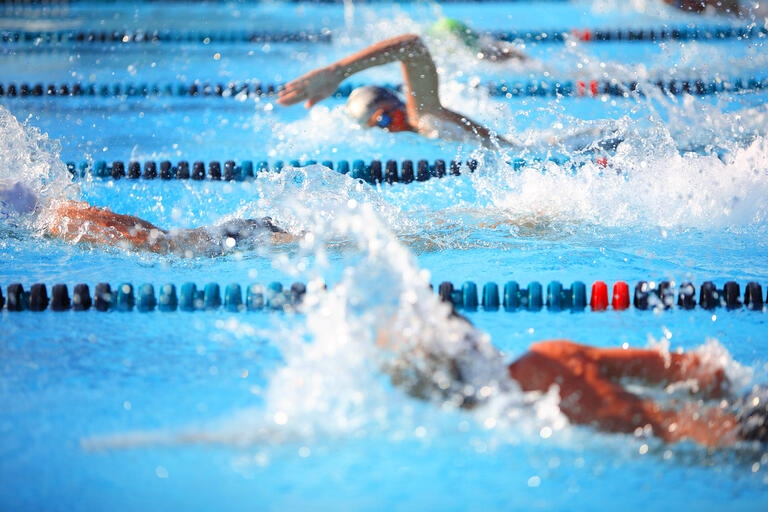 Several swimmers racing at a swim meet
