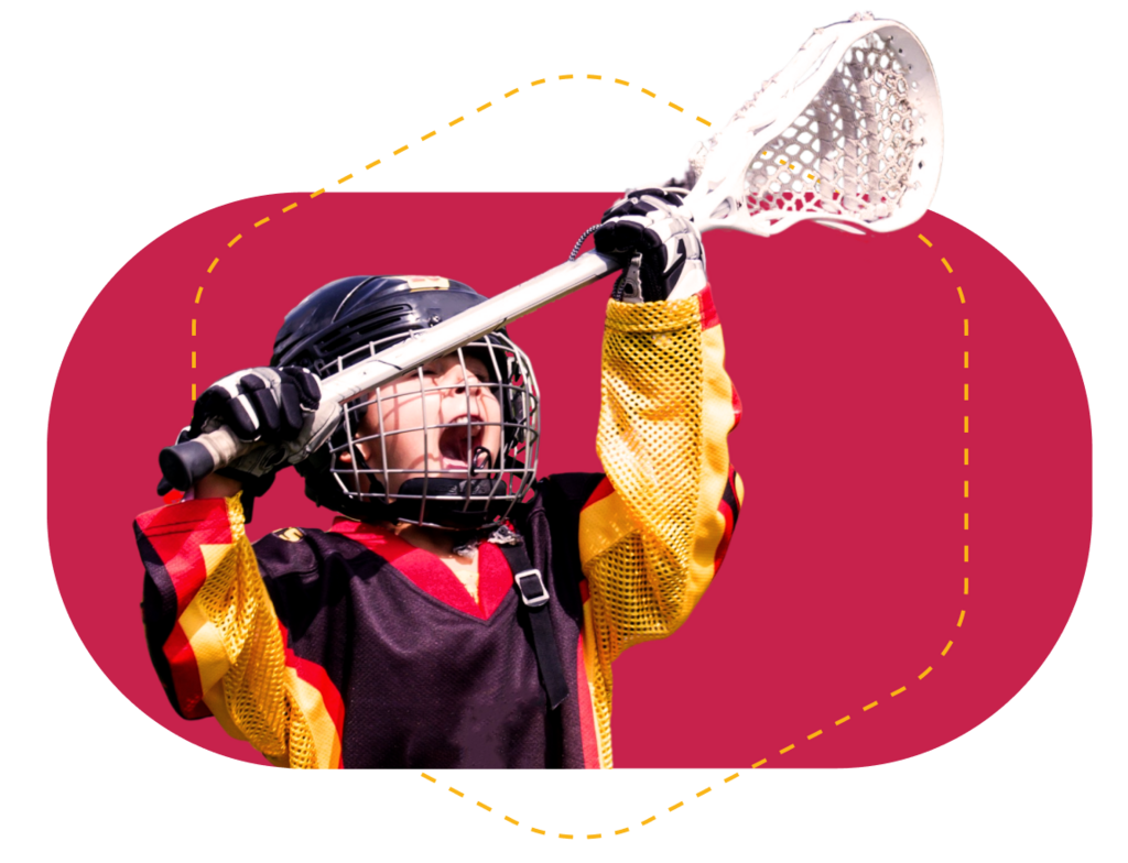 Excited, young lacrosse player holding up lacrosse stick